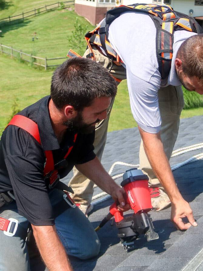 two team members installing roof